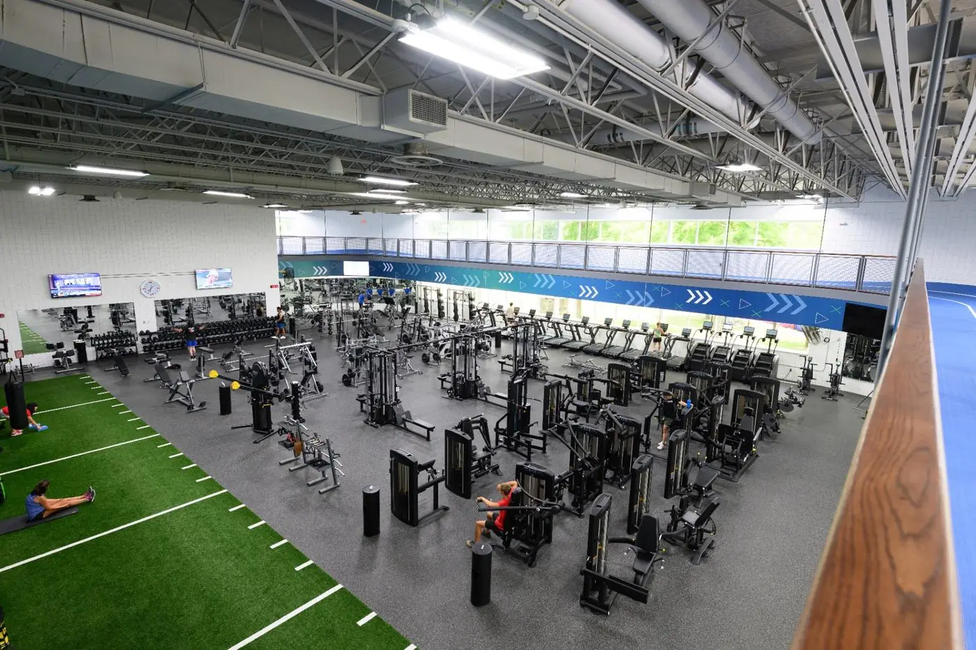 Vista aérea de gimnasio corporativo con zona de cardio, fuerza y césped funcional — Fitness Factory
