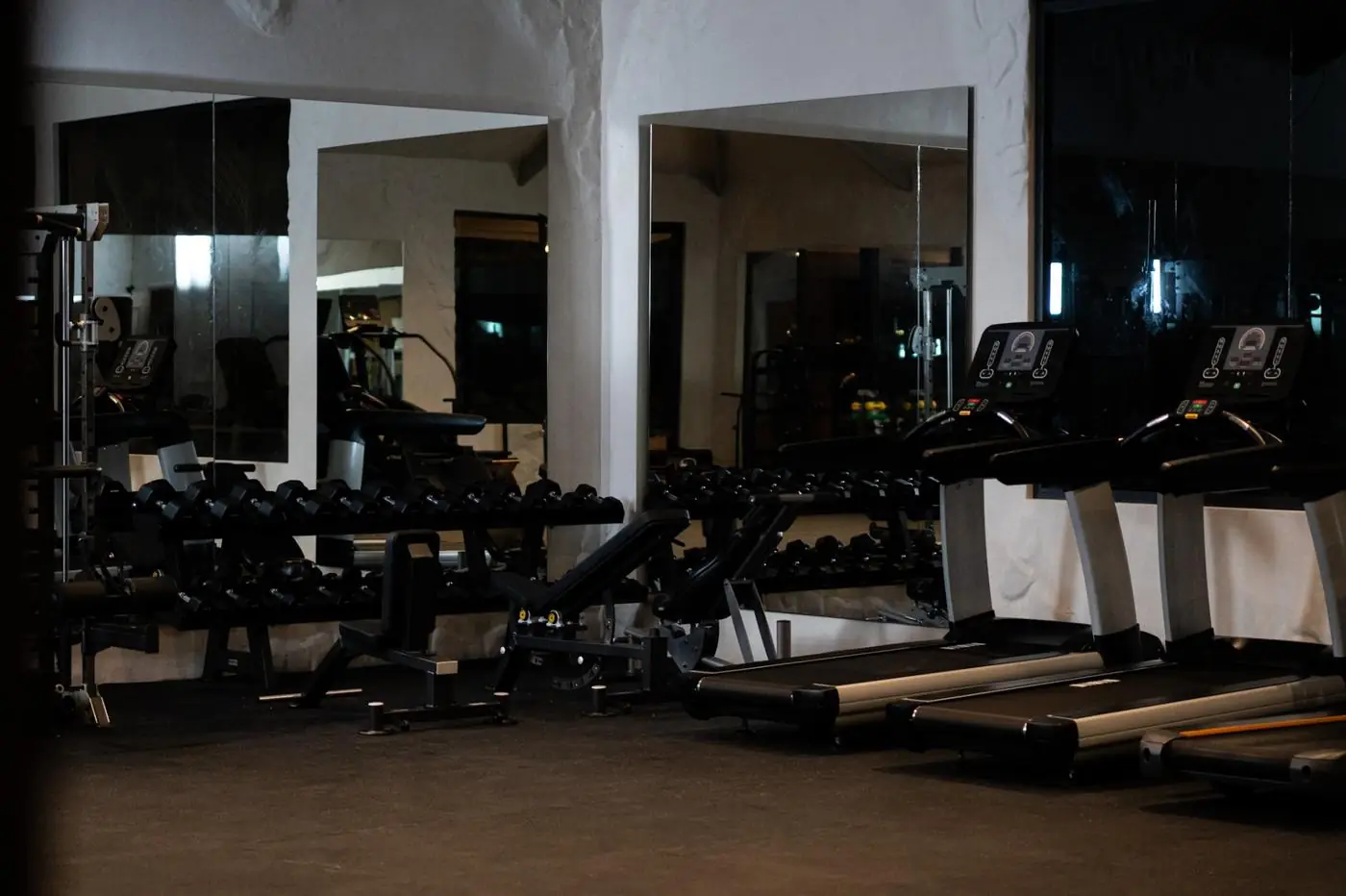 Zona de cardio y fuerza con iluminación tenue en gimnasio de hotel resort — Fitness Factory